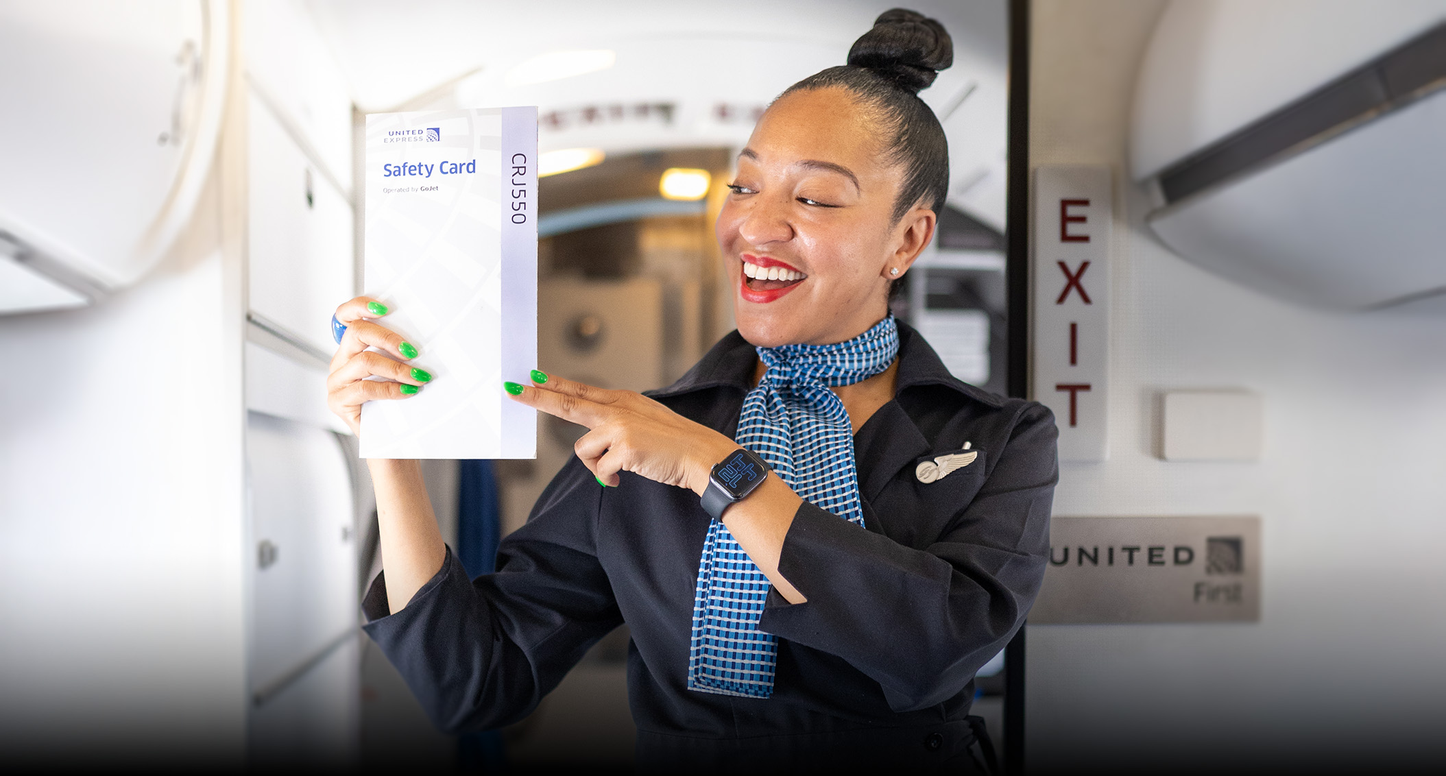 Flight Attendant holding up safety card